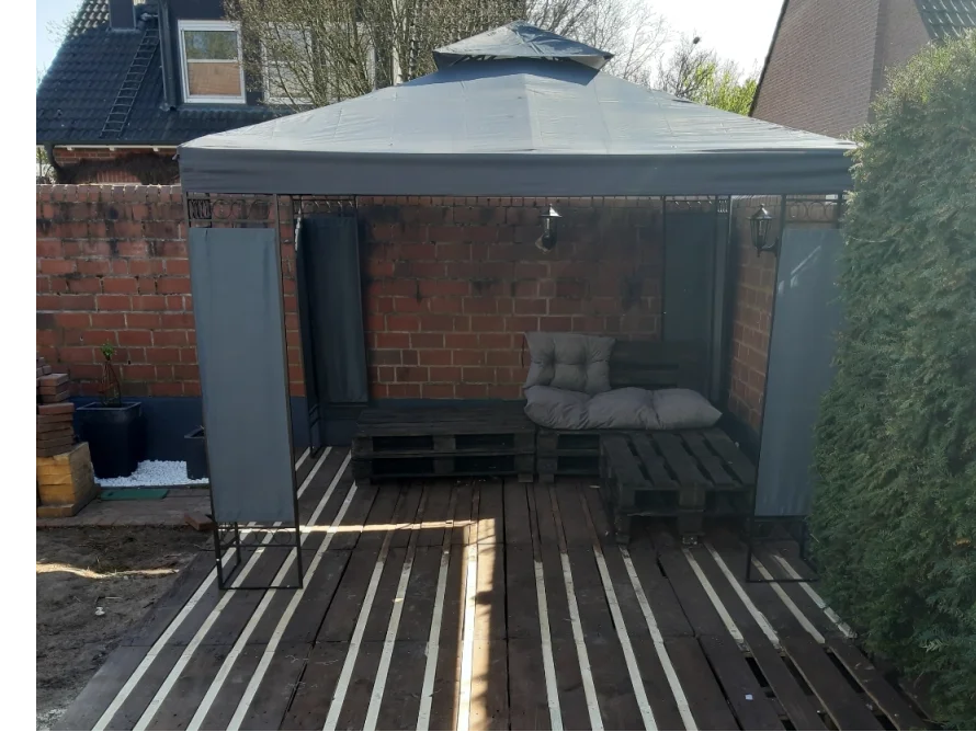 Gartenpavillon auf Holzterrasse mit Palettenmöbeln