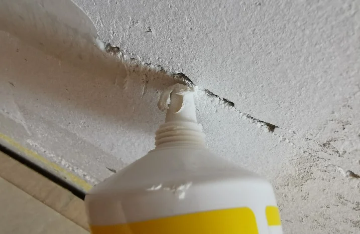 Tube mit Dichtmittel an einem Riss in der Wand