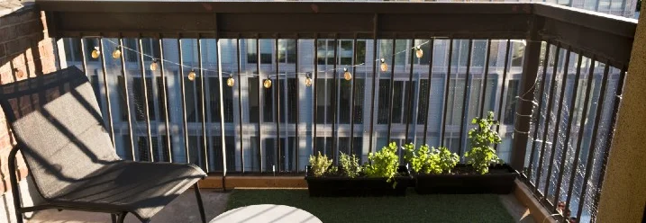 Sonniger Balkon mit Pflanzen und Stuhl