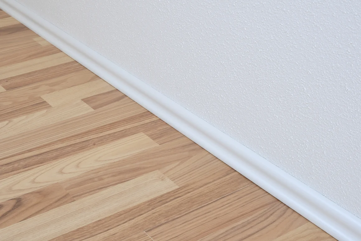 Laminatboden mit weißer Sockelleiste