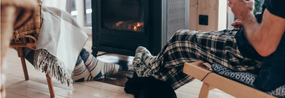 Füße mit Wollsocken vor Kaminofen