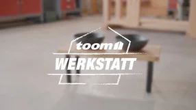 toom Werkstatt Logo mit unscharfem Tisch im Hintergrund