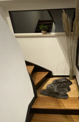 Holztreppe mit schwarzem Geländer