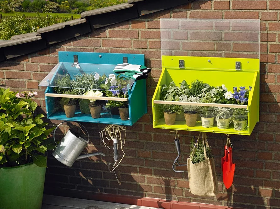 Zwei Blumenkästen an einer Backsteinmauer