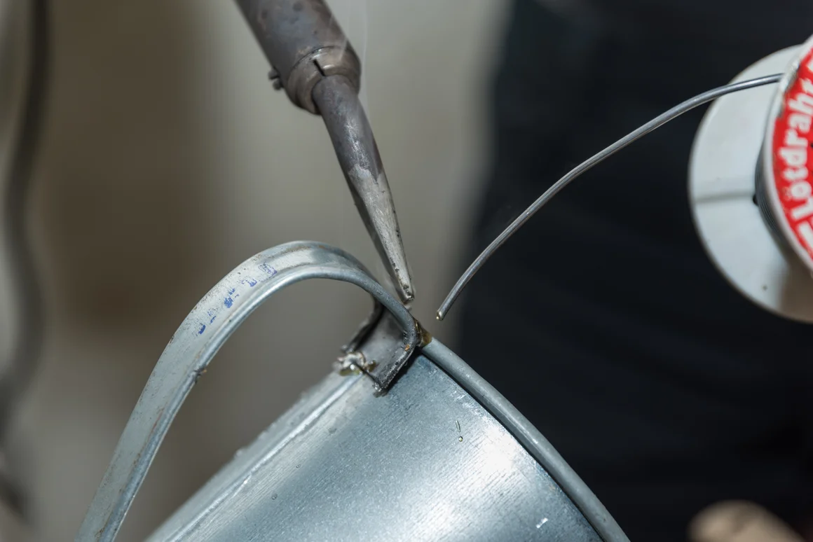 Lötkolben verbindet Metall mit Lötzinn