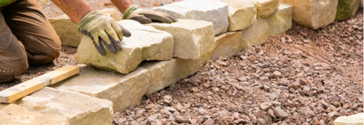 Person baut eine Trockenmauer