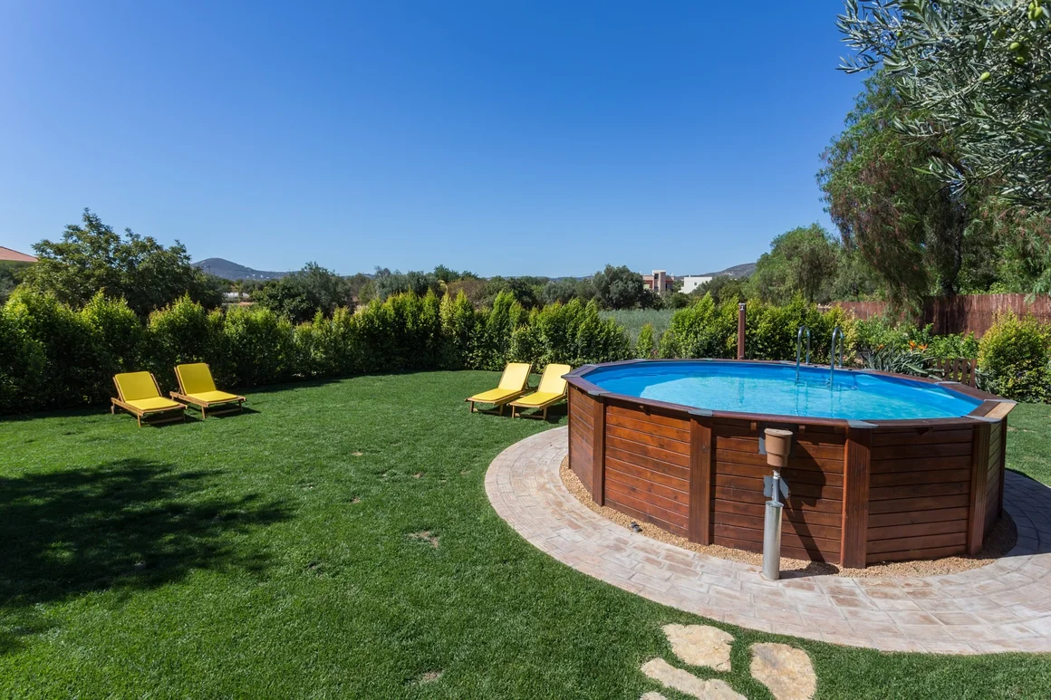Aufstellpool im Garten mit Liegestühlen