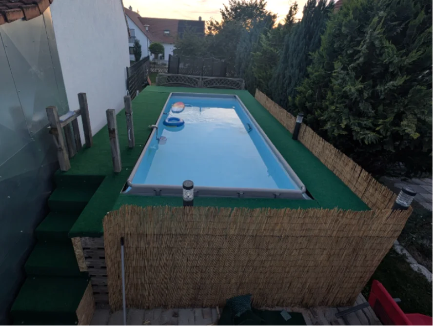 Rechteckiger Pool im Garten mit Kunstrasen und Schilfmatte