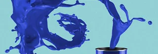Blaue Farbe spritzt aus Farbeimer