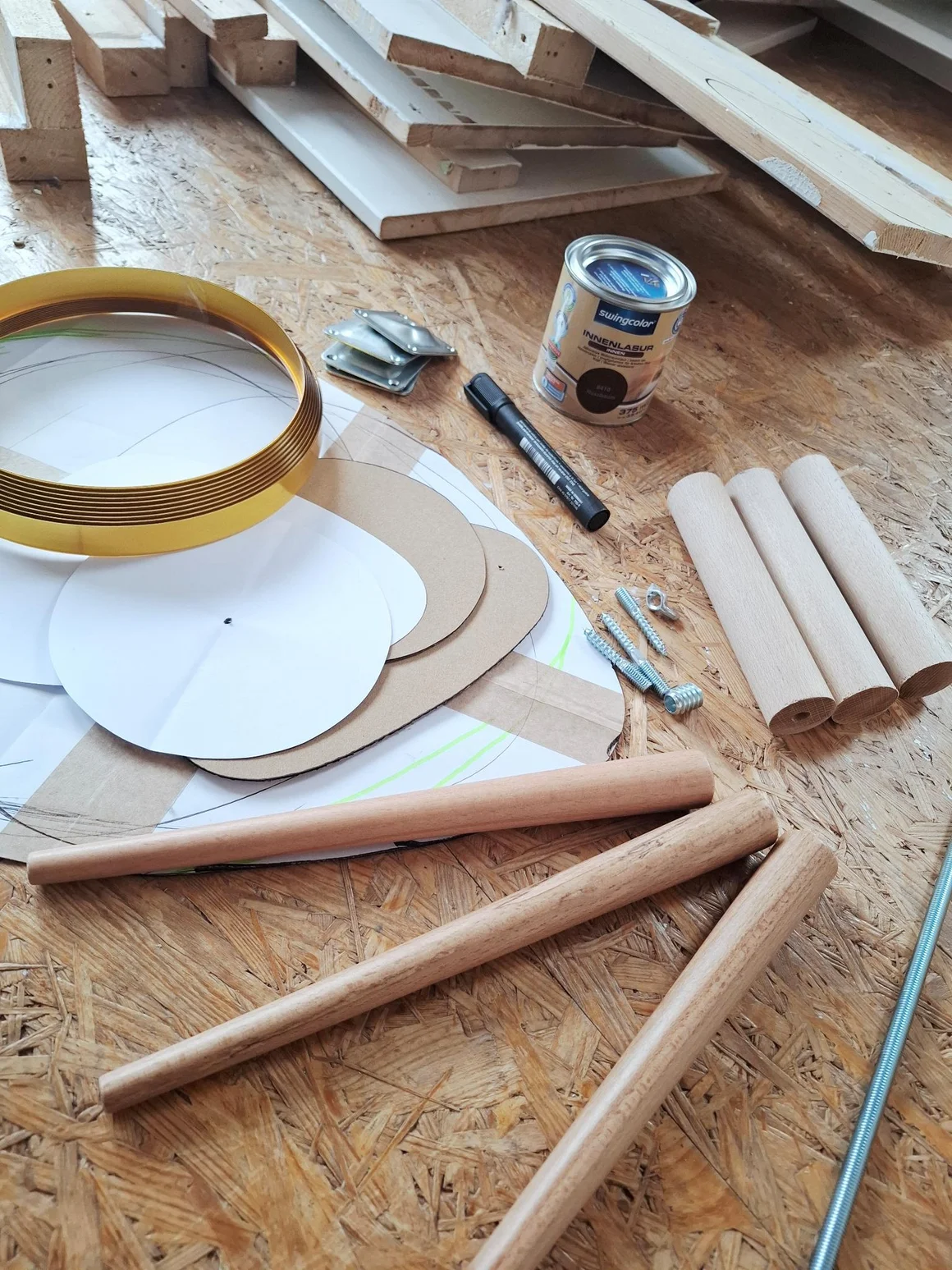 Materialien für ein Heimwerkerprojekt mit Holzstäben und Holzlasur.