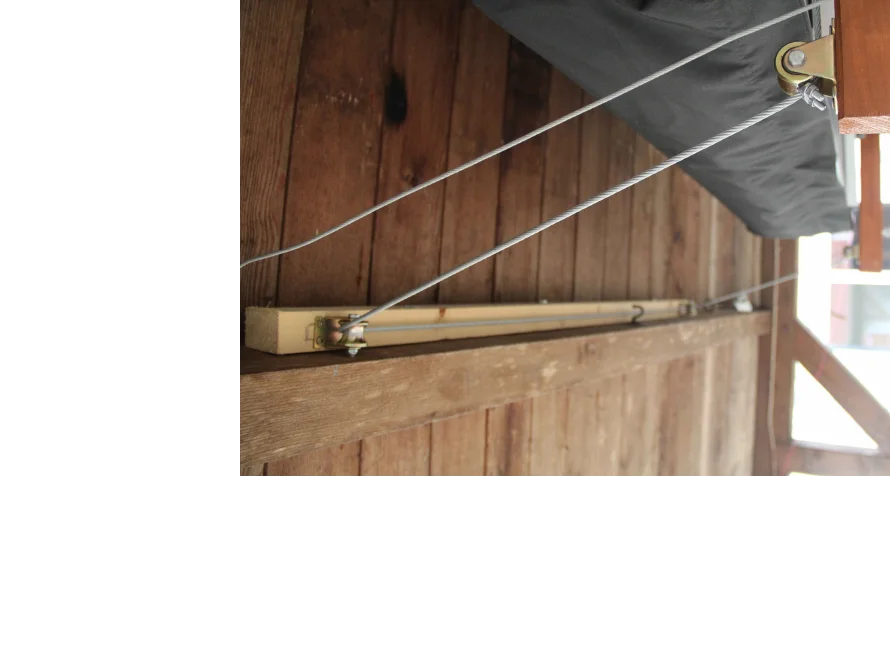 Holzbalken mit Metallseilen an Holzkonstruktion