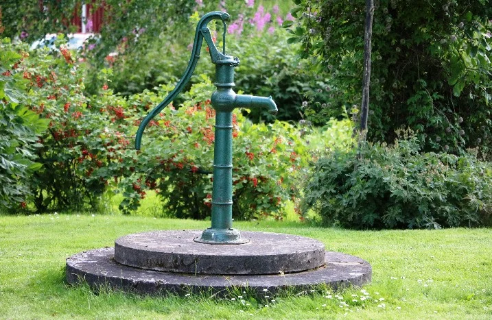 Grüne Wasserpumpe im Garten