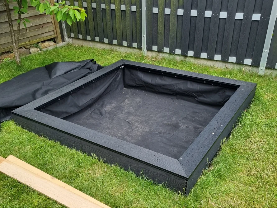 Leerer Sandkasten mit Plane