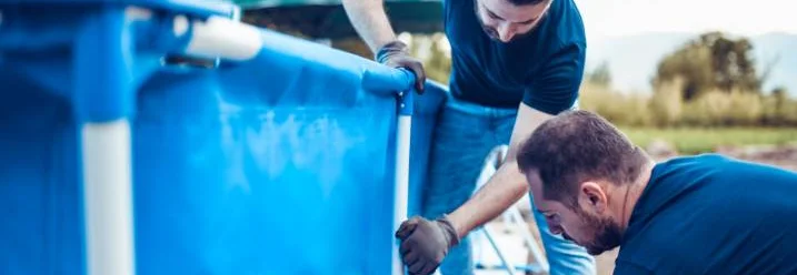 Zwei Personen bauen einen Pool auf.
