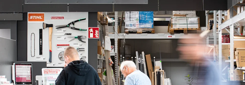 Zwei Personen an einem Abholschalter in einem Baumarkt