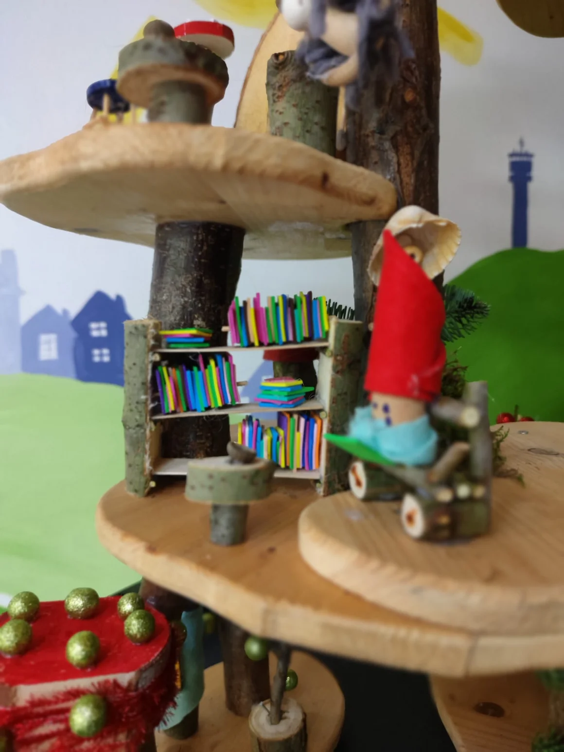 Wichtel mit roter Mütze in einem Baumhaus mit Miniatur-Bücherregal