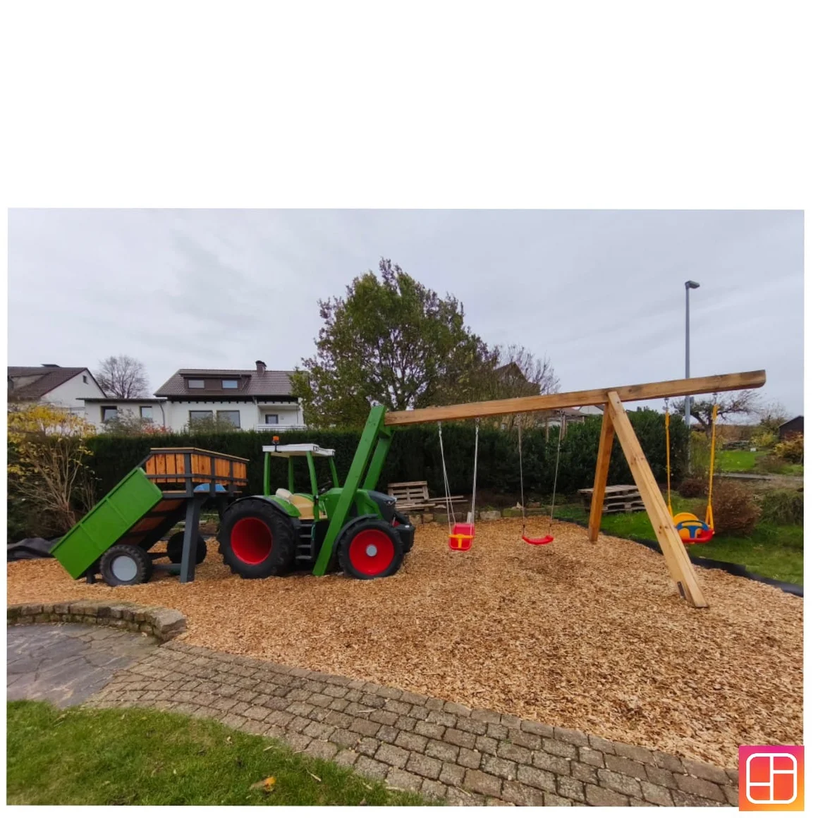 Ein Kinderspielplatz mit einem Klettergerüst in Form eines Traktors.