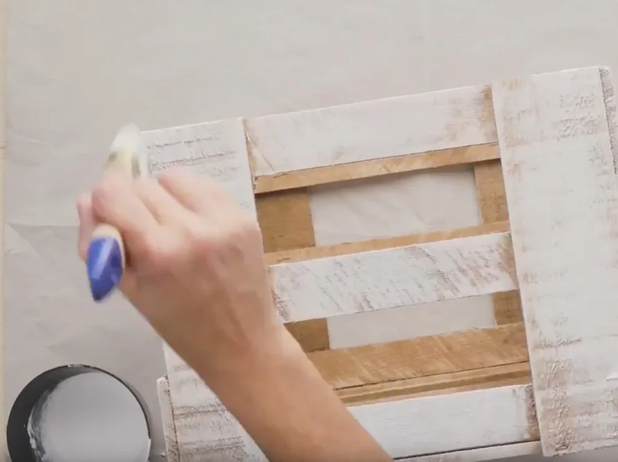 Person bemalt Holzkiste mit Pinsel