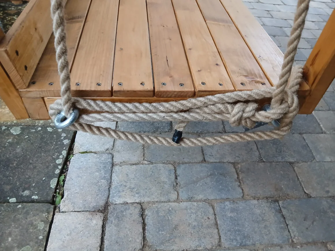 Nahaufnahme der Seilbefestigung einer Holzschaukel.