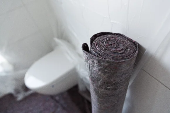 Eine Rolle Maler-Abdeckvlies steht in einem Badezimmer