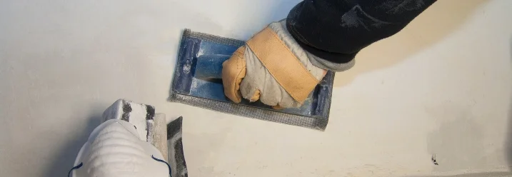 Hand schleift Wand mit Schleifklotz