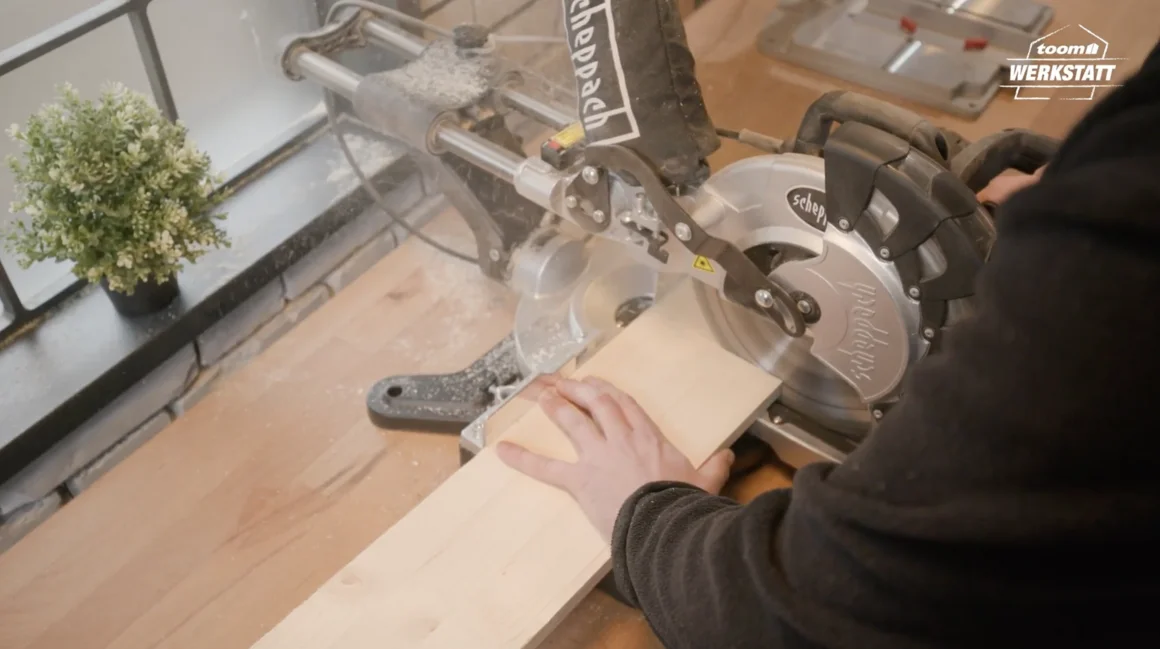 Person sägt Holz mit Kappsäge
