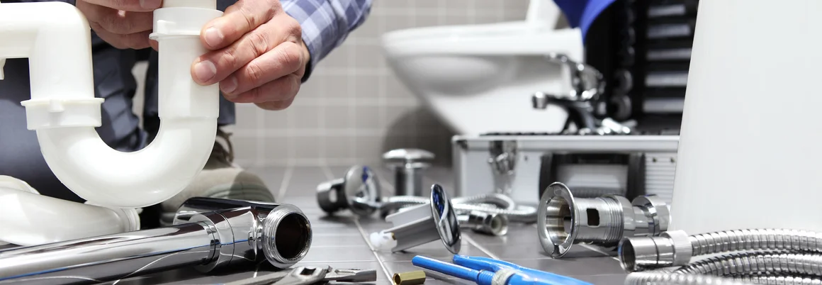 Person montiert ein Siphon mit Rohrzange.