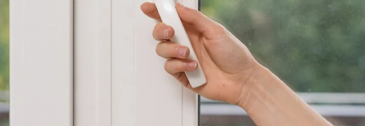 Hand betätigt Fenstergriff.