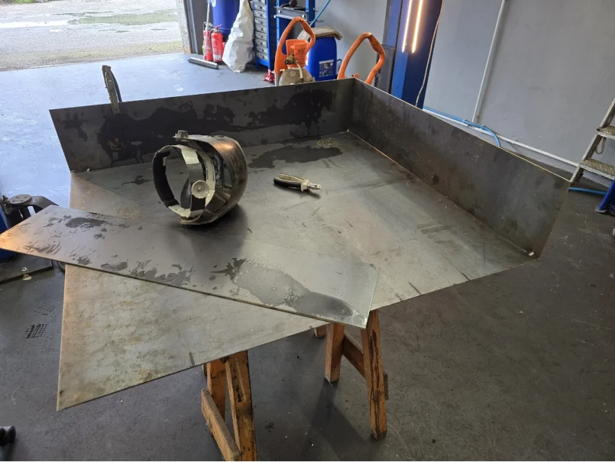 Metallplatten und Schweißmaske auf Arbeitstisch