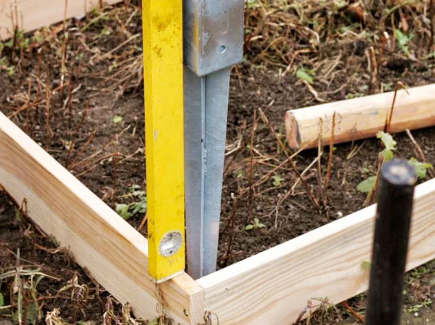 Wasserwaage an einem Holzrahmen im Garten