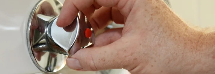 Hand dreht die Wasserzufuhr ab.