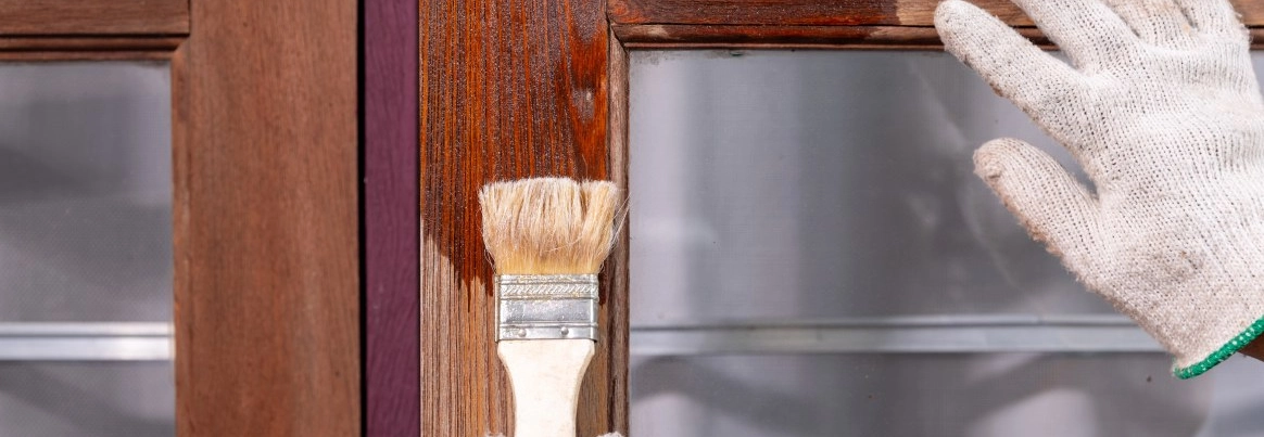 Person lasiert Fenster
