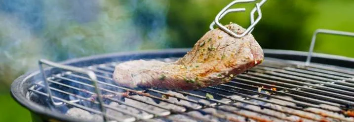 Steak wird mit Grillzange gegrillt