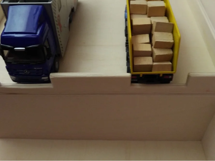 Spielzeuglastwagen in einem Holzregal