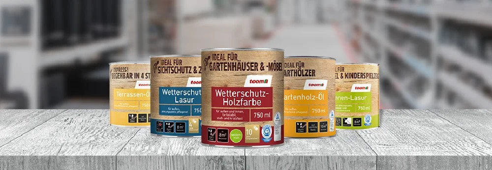Fünf Dosen Holzschutzmittel auf einem Holztisch