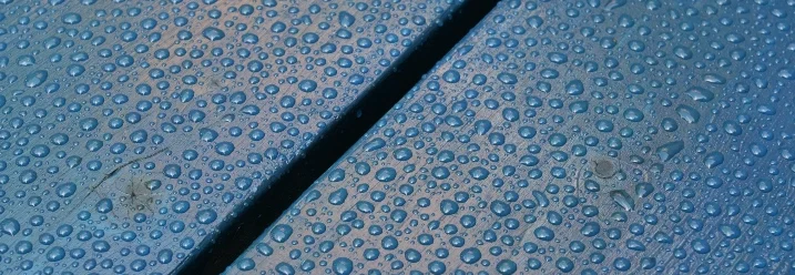 Wassertropfen auf blauen Holzbrettern