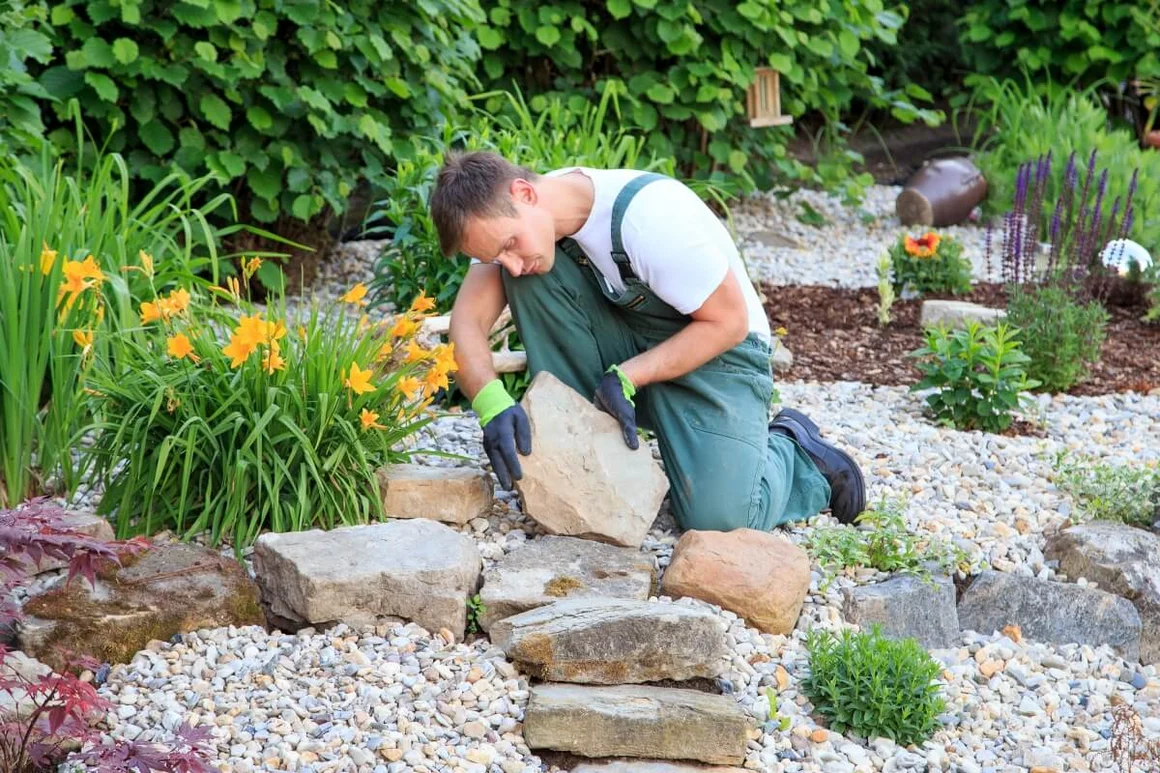 Person baut Steinweg in einem Garten