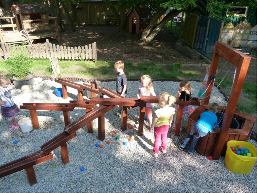 Kinder spielen mit einer Murmelbahn