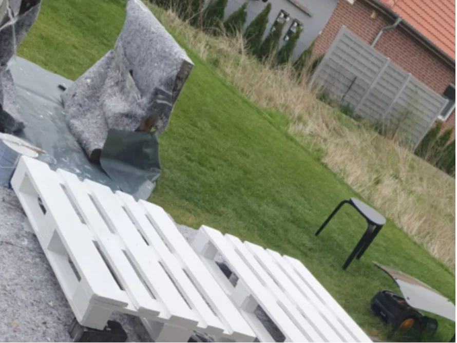 Weiße Holzpaletten auf Rasen
