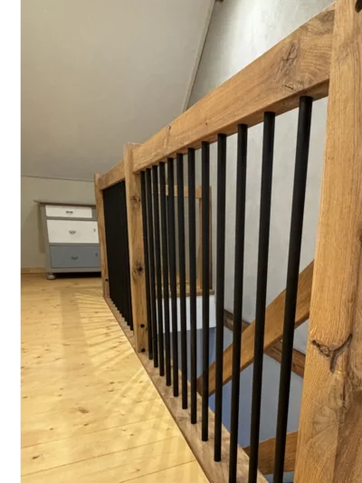Holztreppe mit schwarzen Metallstäben