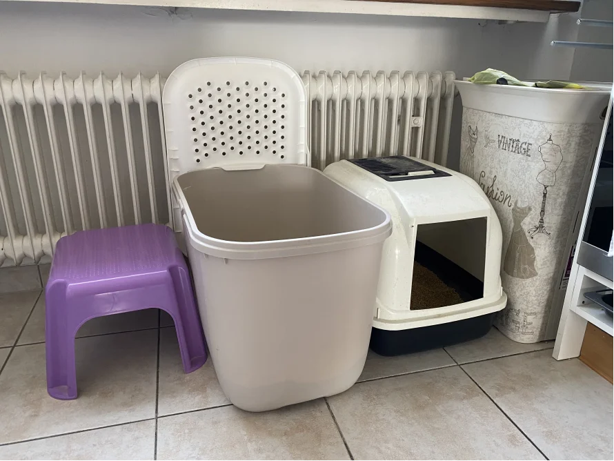 Katzentoilette und -behälter neben Heizkörper