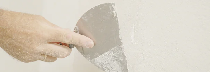 Person spachtelt eine Wand