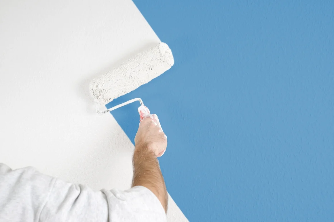 Person streicht Wand blau