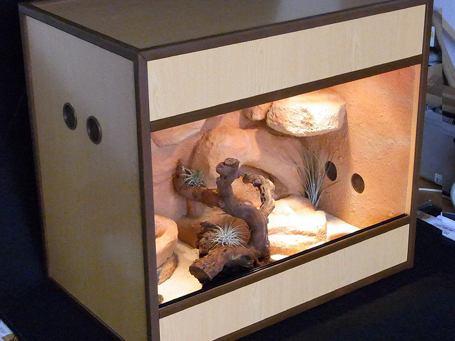 Ein Terrarium aus Holz mit Felslandschaft.