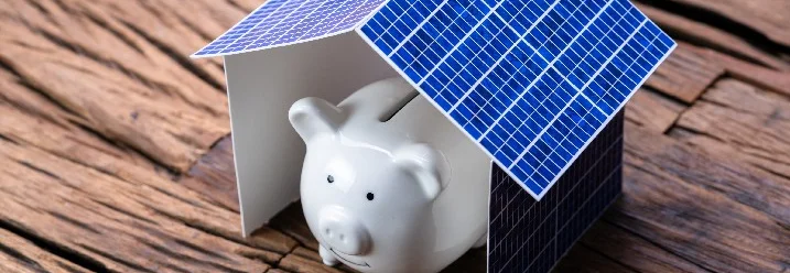 Sparschwein unter einem kleinen Solarzellen-Haus