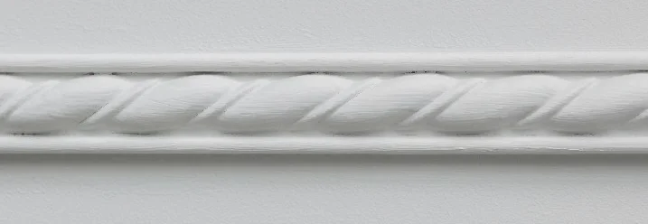 Weißer Stuck mit Seilmuster an einer Wand.