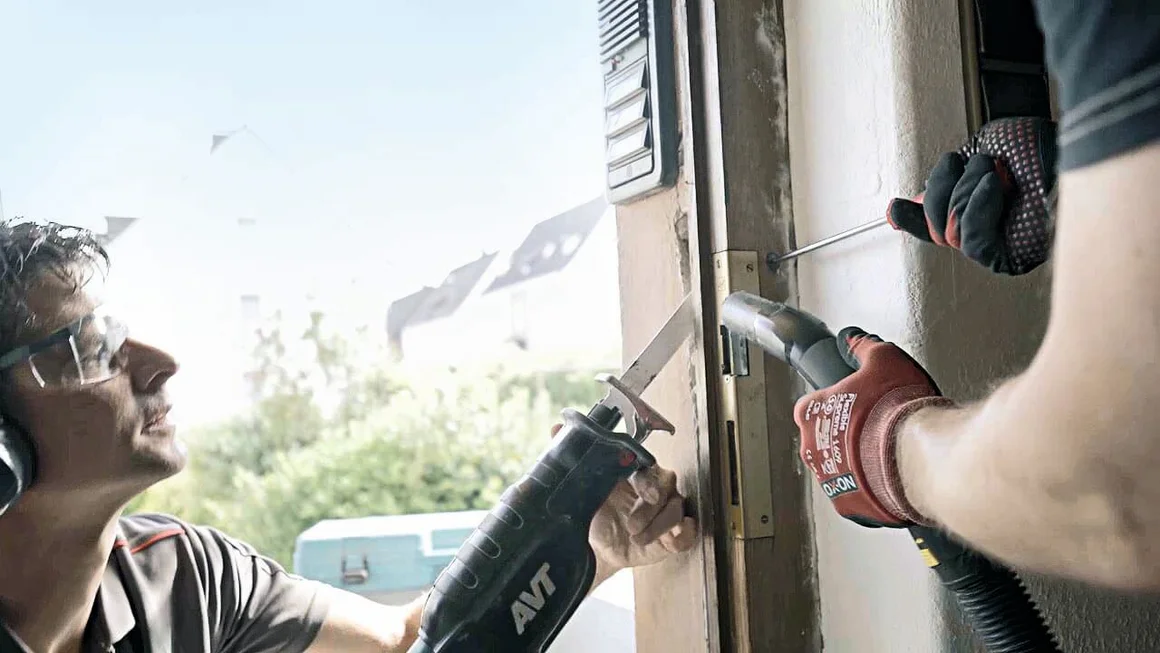 Zwei Personen bauen eine Tür mit Stichsäge und Staubsauger ein.