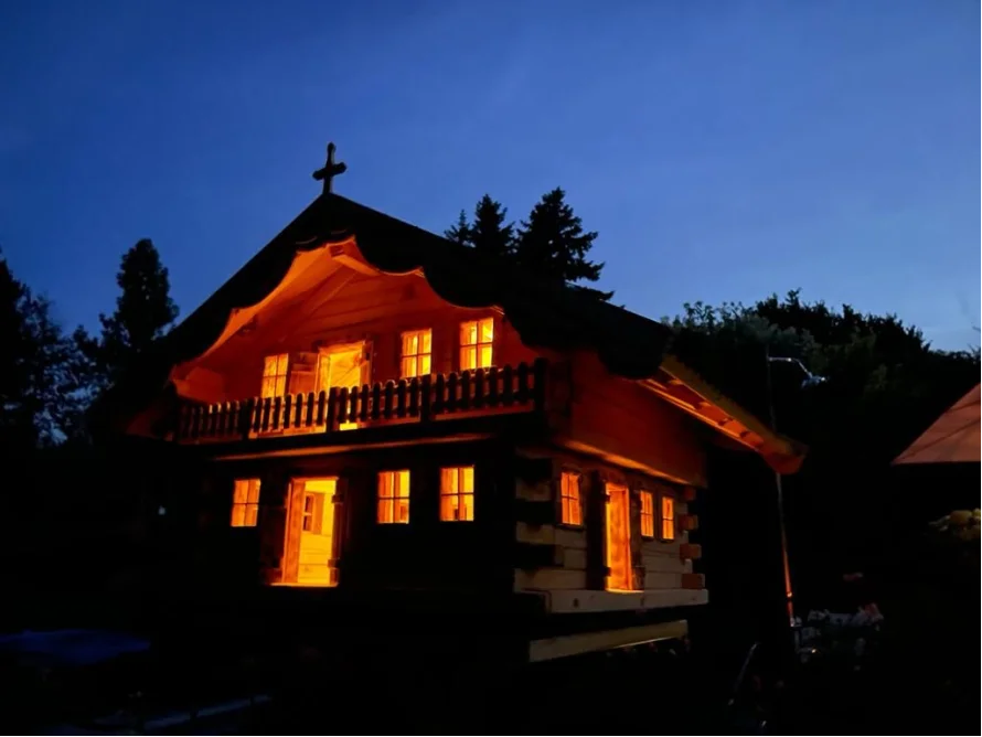Hölzernes Gartenhaus bei Nacht beleuchtet