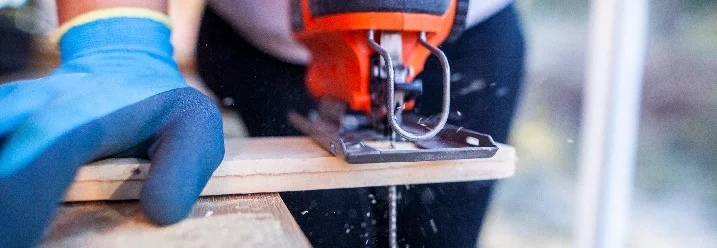 Person sägt Holz mit Stichsäge