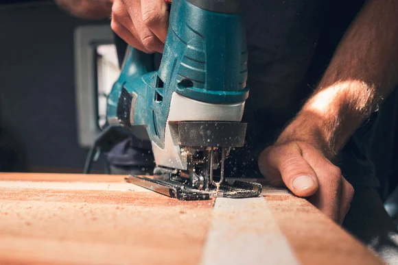 Person sägt Holz mit Stichsäge